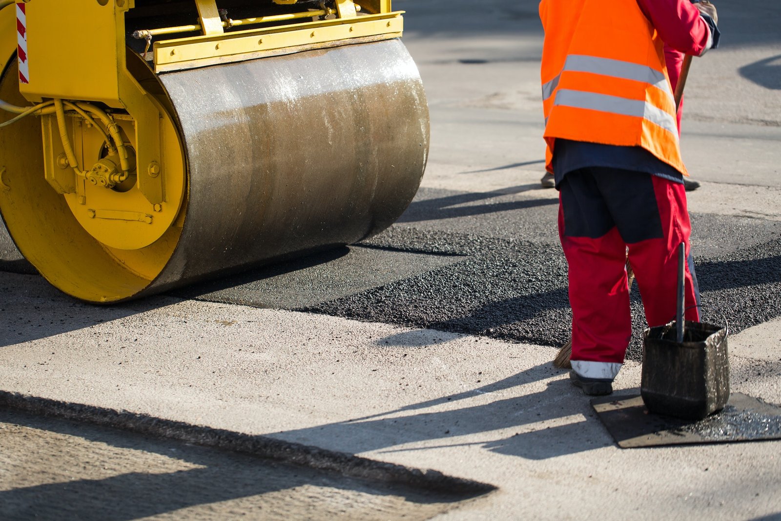 Road repairs. A road roller compacting asphalt